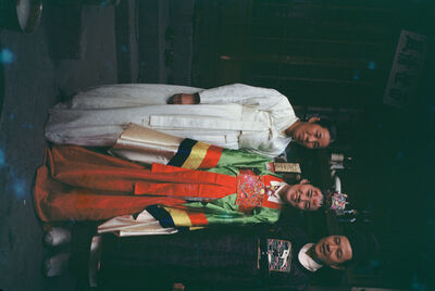 A bride a groom, and an old woman wearing Korean traditional dress
