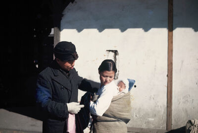 a man and a woman with a baby on her back
